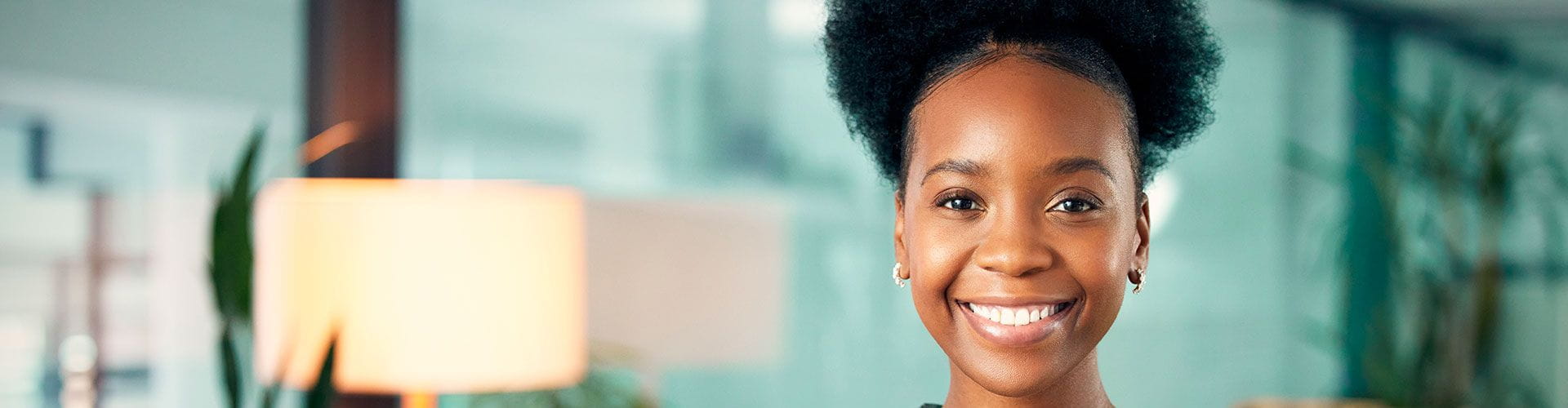 Femme souriante face à l’objectif dans un milieu professionnel