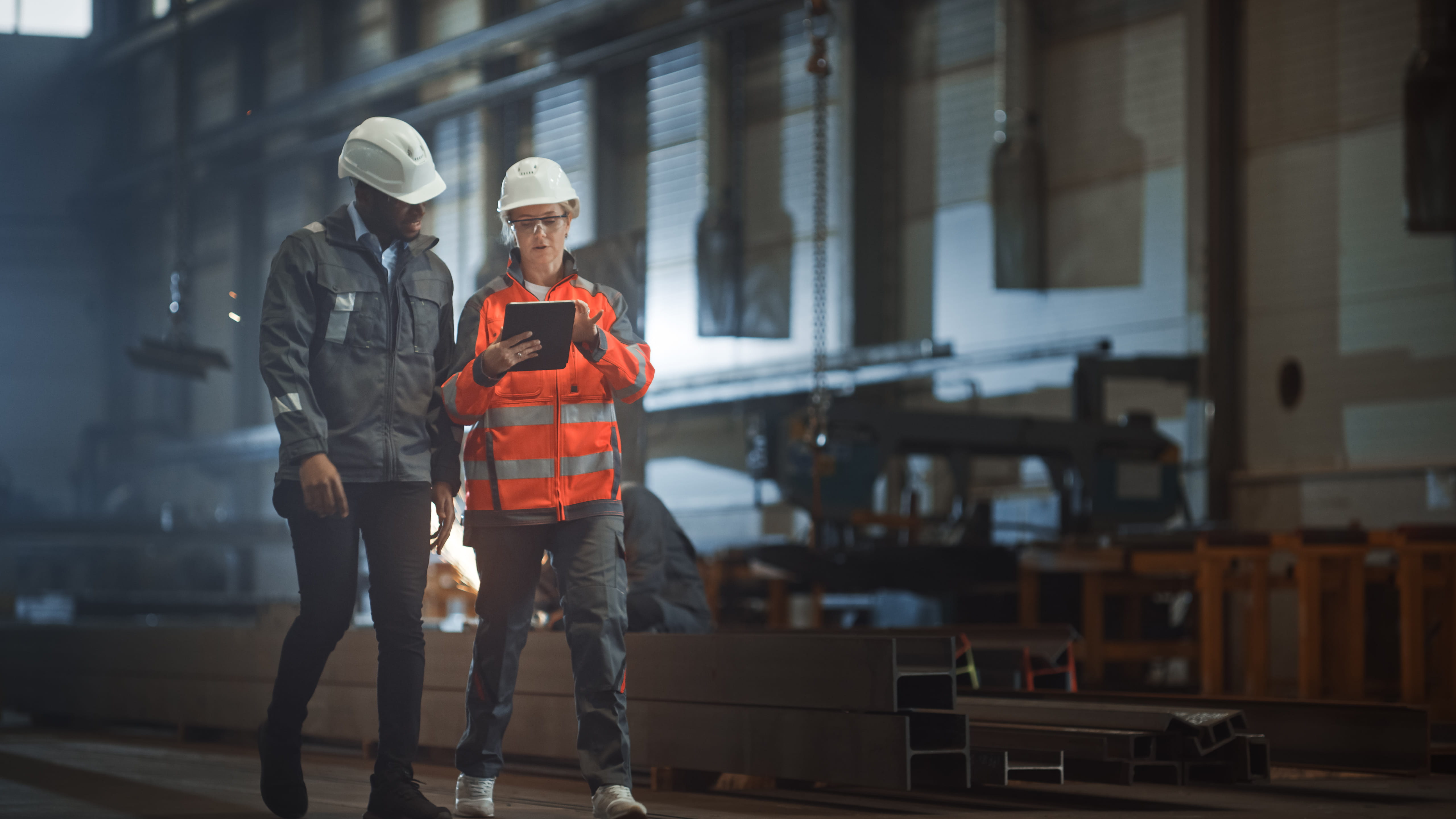 Two Heavy Industry Engineers Walk in Steel Factory